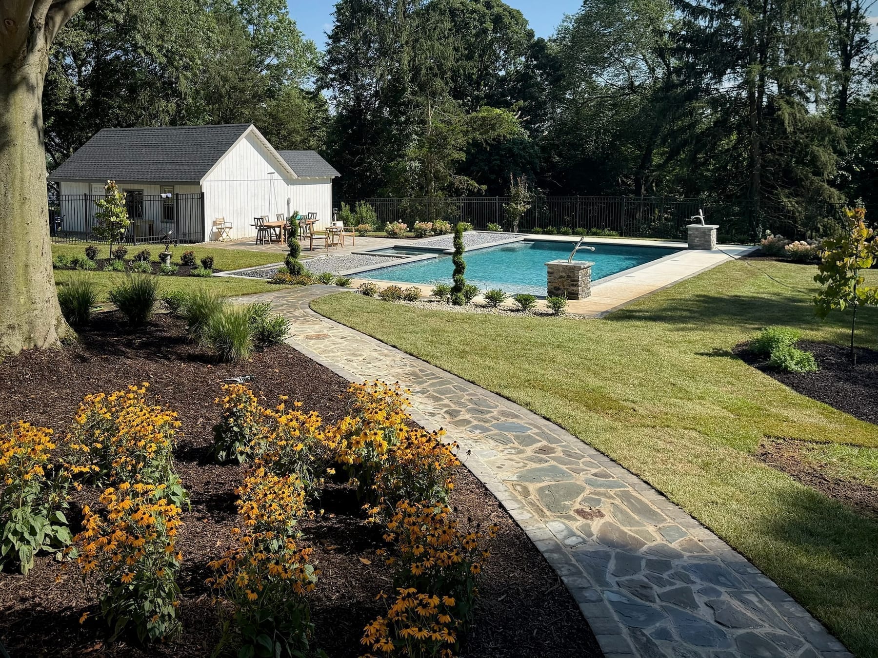 Backyard pool with flagstone walkway and bordering garden beds